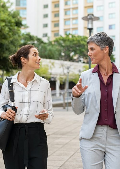 Mature business women in conversation while walking